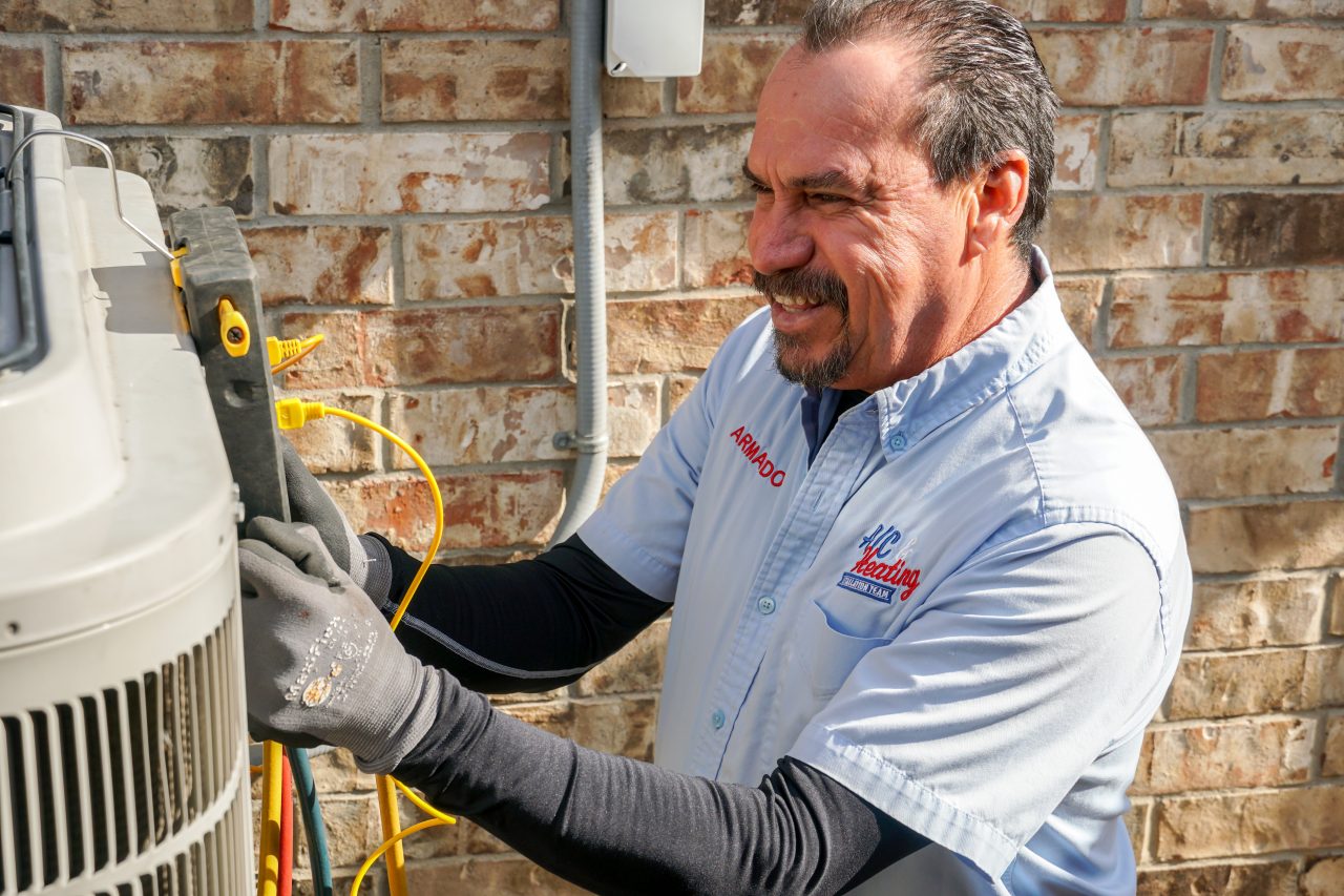 HVAC technician servicing an outdoor air conditioning unit