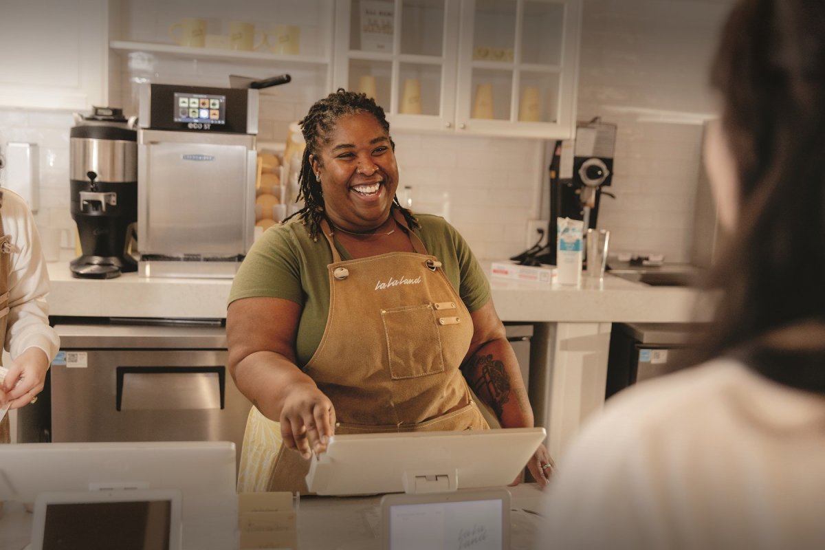 Smiling barista interacting with a customer in a Texas coffee shop
